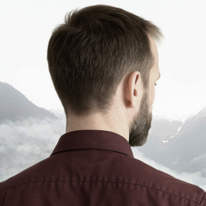 Homme de dos face à des monts brumeux